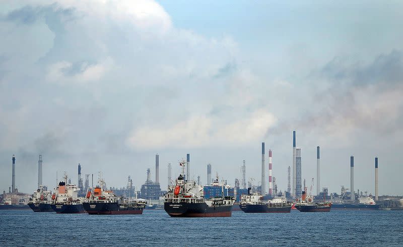FILE PHOTO: Ships are seen anchored in front of a refinery on Singapore's Bukom Island