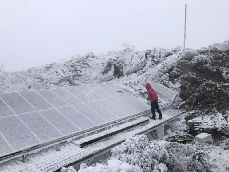 20210110-玉山氣象站同仁在雪地中清除太陽能板上的積雪以利其順暢運作。（取自鄭明典臉書）