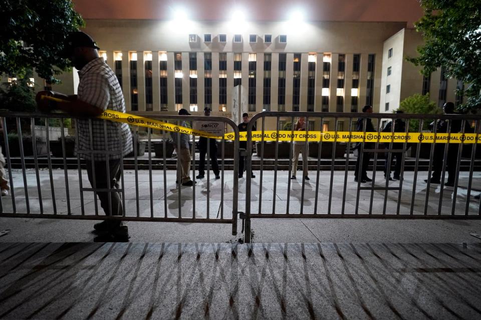 Workers put up barricades and secure the area outside the E. Barrett Prettyman U.S. Federal Courthouse (AP)