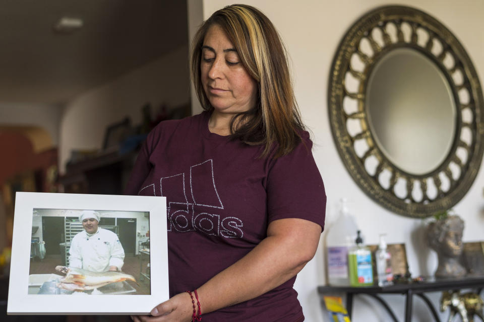 Laura Ramos holds a photo of her brother Jerry Ramos at her home in Watsonville, Calif., Sunday, June 6, 2021. He died Feb. 15 at age 32, becoming not just one of the roughly 600,000 Americans who have now perished in the outbreak but another example of the virus’s strikingly uneven and ever-shifting toll on the nation’s racial and ethnic groups. (AP Photo/Nic Coury)