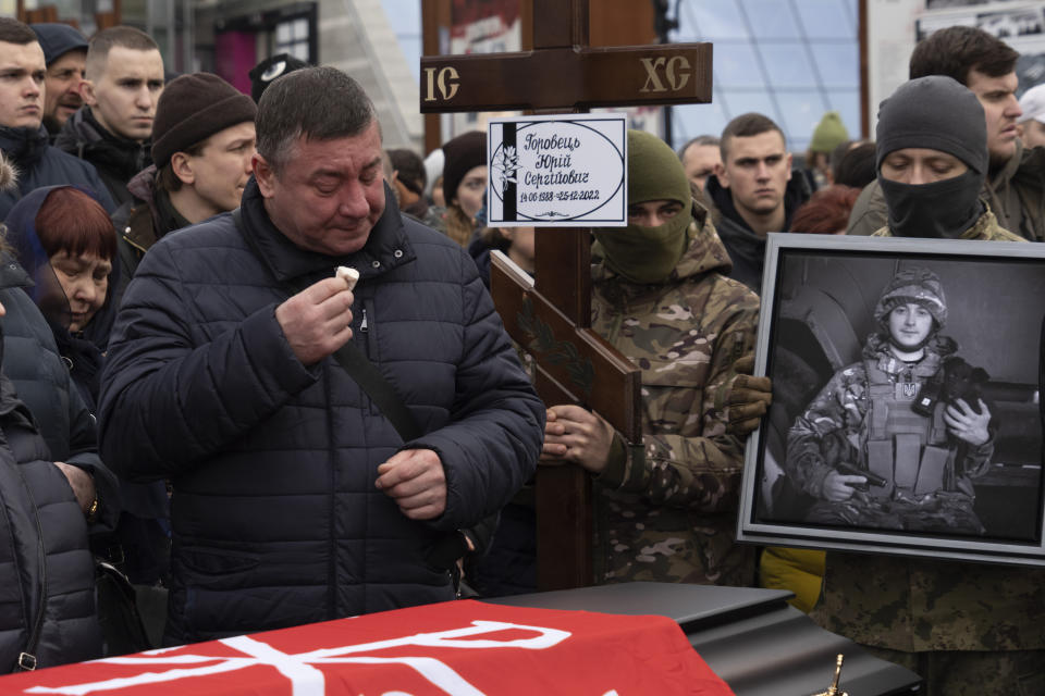 Parents mourn over a coffin of Yuri Horobets, 34, one of four Ukrainian servicemen who were part of a reconnaissance group and were killed on Dec. 25 in Russia as they performed a special task, during a farewell ceremony on the Independence square in Kyiv, Ukraine, Tuesday, March 7, 2023. Names of other servicemen are Maksym Mykhailov, 32, Yuri Horobets, 34, Taras Karpiuk, 36. (AP Photo/Efrem Lukatsky)