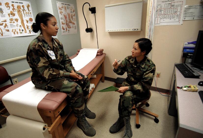 Lt. Col. Mylene Huynh, commander of the 377th Medical Group at Kirtland AFB interviews Staff Sgt. Alisha Armendariz about her complaint of lower back pain, April 30, 2008. (AP Photo/Albuquerque Journal)