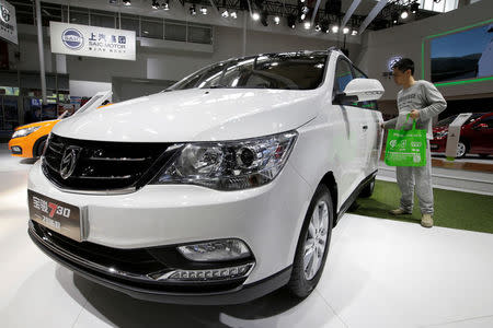 A visitor looks at a Baojun 730 model from SAIC-GM-Wuling Automobile presented during the Auto China 2016 auto show in Beijing May 4, 2016. REUTERS/Jason Lee