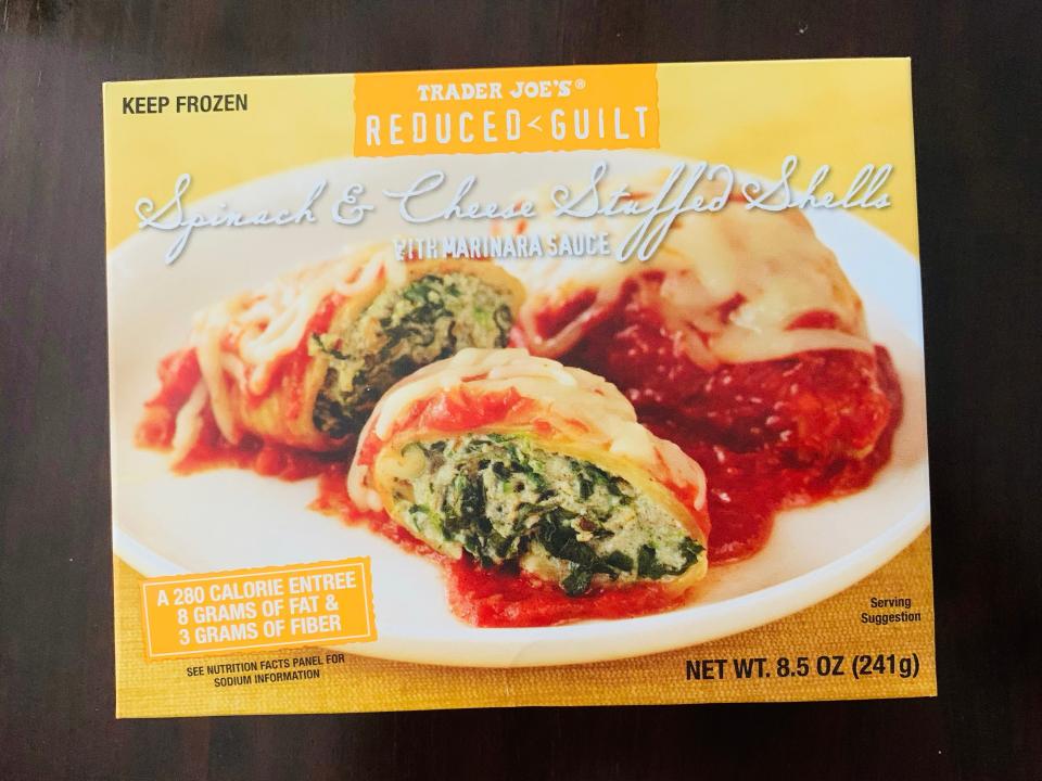 Trader joe's yellow box of frozen stuffed shells on wooden table