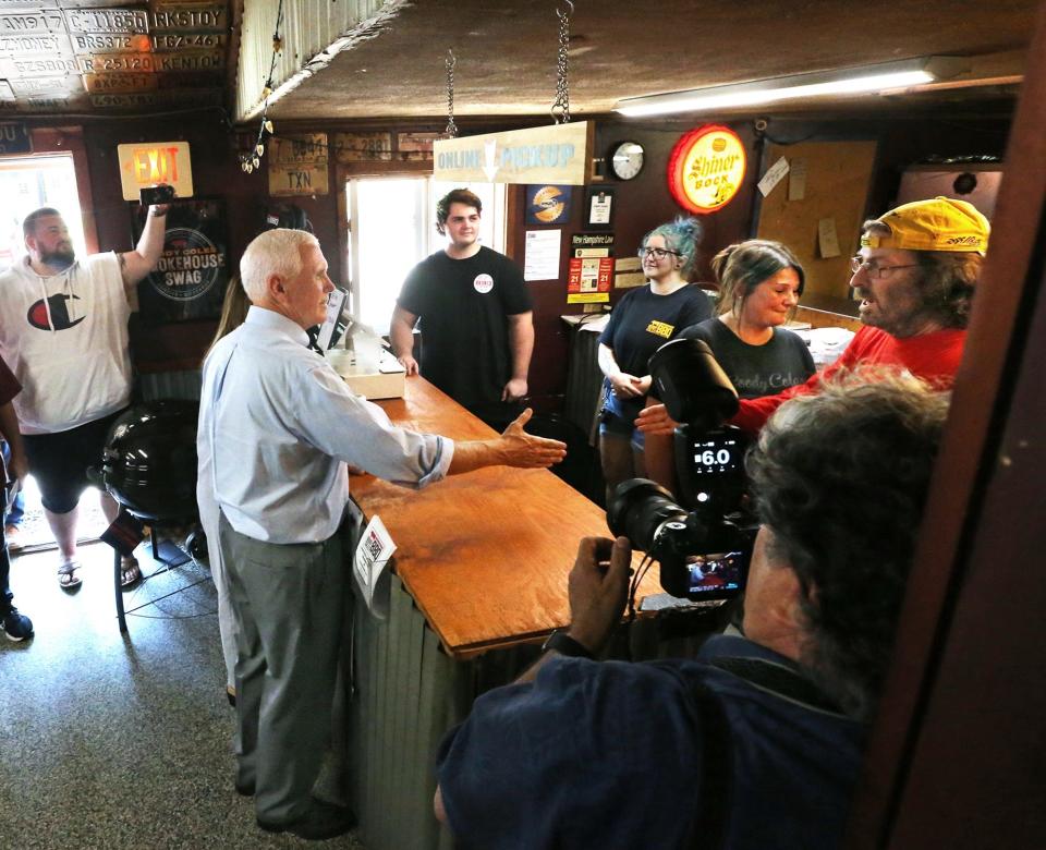 Former Vice President Mike Pence shakes hands with employees at Goody Cole's Smokehouse in Brentwood, N.H., on July 20, 2023.