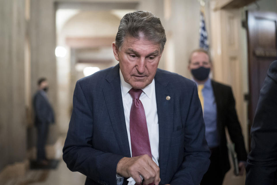 FILE - Sen. Joe Manchin, D-W.Va., leaves the office of Senate Minority Leader Mitch McConnell, R-Ky., after a lengthy meeting at the Capitol in Washington, Nov. 30, 2021. President Joe Biden faces a steep path to achieve his ambitious goal to slash planet-warming greenhouse gas emissions in half by 2030, as a $2 trillion package of social and environmental initiatives remains stalled. Biden’s Build Back Better plan, which contains $550 billion in spending and tax credits aimed at promoting clean energy, was sidetracked by Manchin, who said just before Christmas that he could not support the legislation as written. (AP Photo/J. Scott Applewhite, File)
