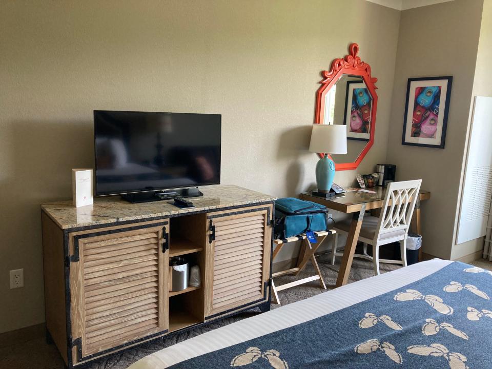 A hotel room with a desk and TV at the Dollywood DreamMore Resort.