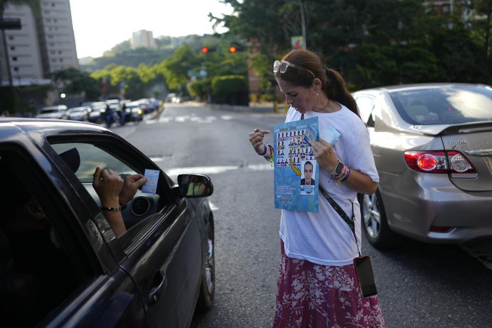 Una partidaria del candidato opositor a la presidencia Edmundo González muestra cómo votar por él durante un acto de campaña en Caracas, Venezuela, el viernes 19 de julio de 2024. Las elecciones están programadas para el 28 de julio. (AP Foto/Ariana Cubillos)