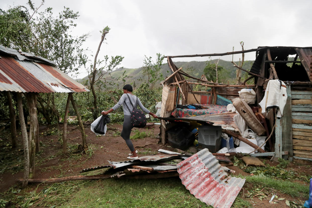 A woman removes rubble from her destroyed house in the aftermath of Hurricane Fiona, in El Seibo, Dominican Republic