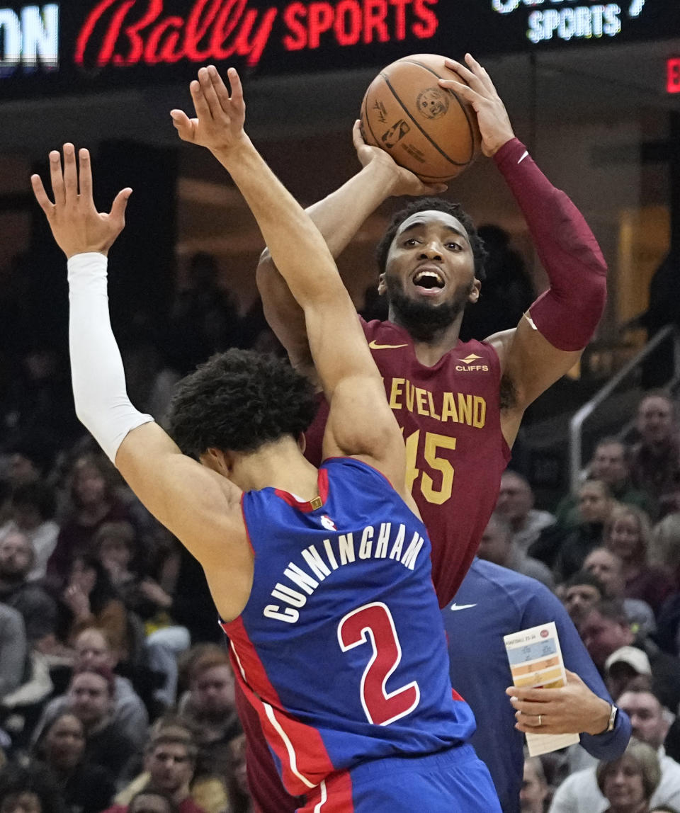Cleveland Cavaliers guard Donovan Mitchell (45) shoots over Detroit Pistons guard Cade Cunningham (2) in the first half of an NBA basketball game, Wednesday, Jan. 31, 2024, in Cleveland. (AP Photo/Sue Ogrocki)