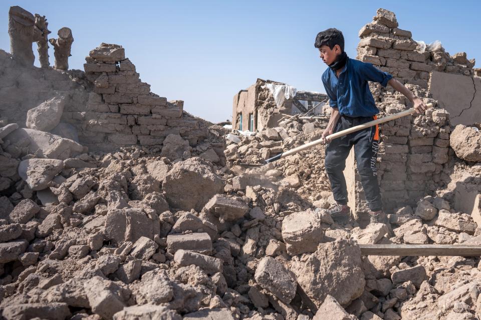Thirteen-year-old Unse digs for pots of flour buried under what was his kitchen in San Job village, Zidan Jan District, western Afghanistan.