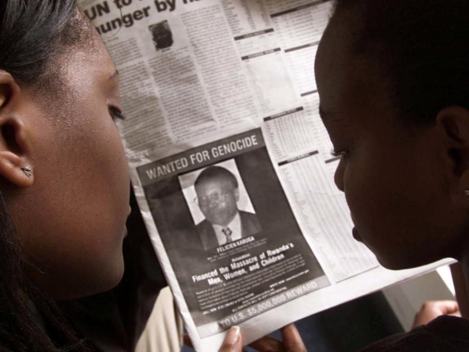 Readers look at a newspaper on 12 June 2002 in Nairobi, Kenya, carrying the photograph of Felicien Kabuga: REUTERS