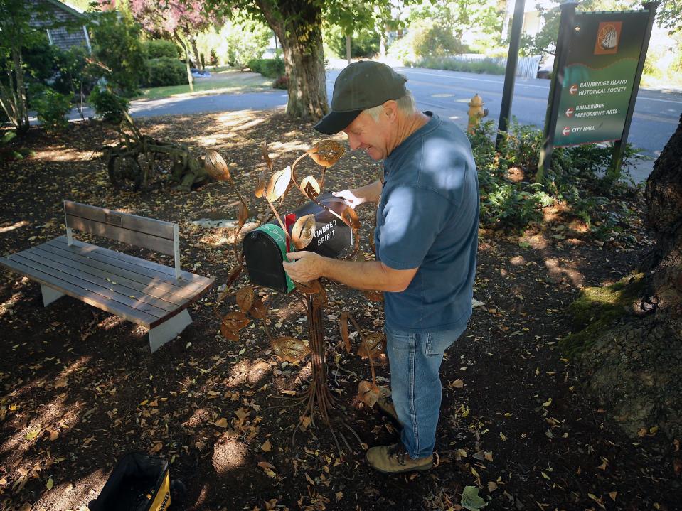 David Harry moves a Kindred Spirit Mailbox into position before he fastens it onto the base made by local metal artist Dick Strom, at the Bainbridge Island Historical Museum on Sept. 14.