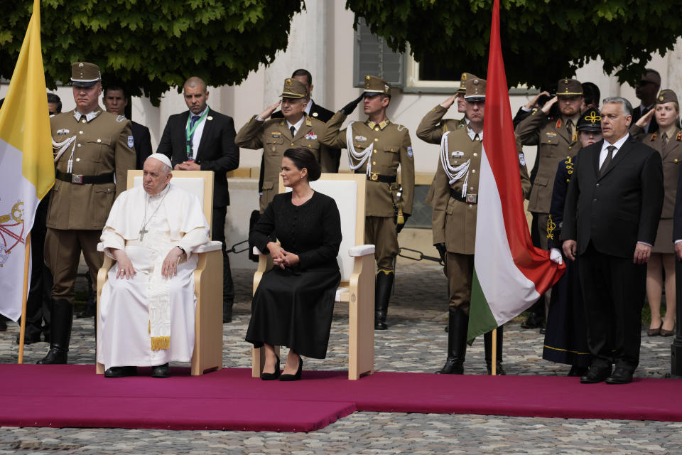 Pope Francis, left is welcomed by Hungary President Katalin Novák, center, and Hungary Prime Minister Viktor Orban in the square of "Sándor" Palace in Budapest, Friday, April 28, 2023. The Pontiff is in Hungary for a three-day pastoral visit. (AP Photo/Andrew Medichini)