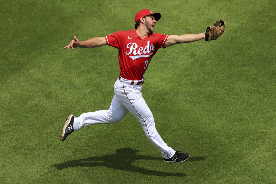 Cincinnati Reds' Max Schrock leaps to make a catch on a fly ball during the third inning of a baseball game in Cincinnati, Sunday, May 23, 2021. (AP Photo/Aaron Doster)