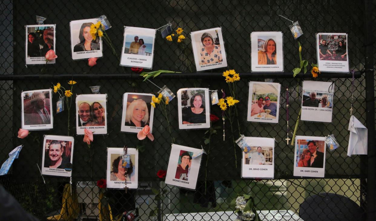 A memorial wall of flowers and photos grows at the intersection of 88th St. and Harding Ave. near the collapsed Champlain Towers South Condo in Surfside, Fla., near Miami, on Monday, June 28, 2021.