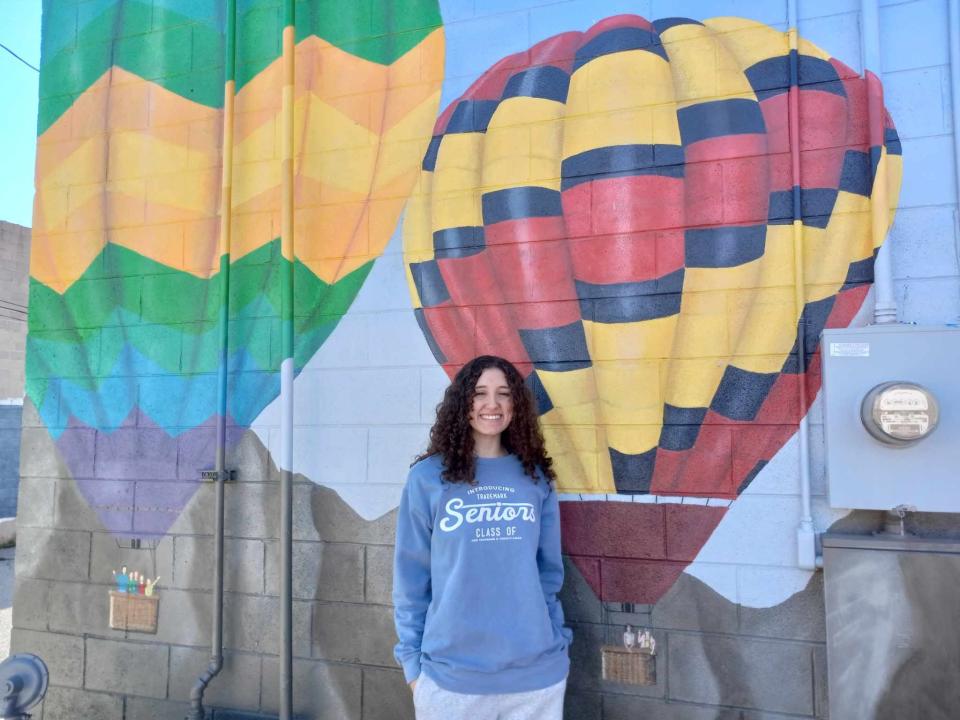 Artesia High swimmer Savana Watts poses in front of a mural she helped pain during the summer of 2023.