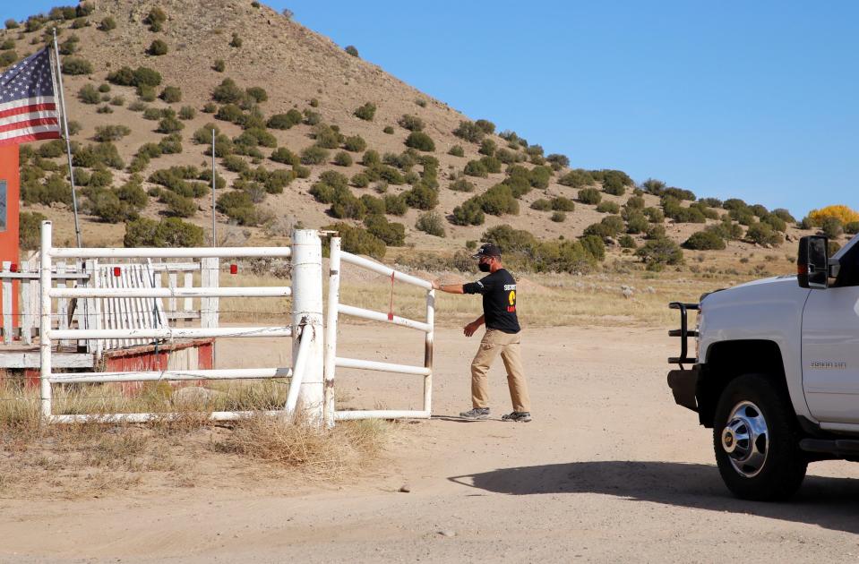 A security guard opens Gate One at the Bonanza Creek Ranch south of Santa Fe, New Mexico, where "Rust" was being filmed.