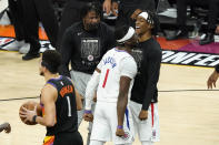 Los Angeles Clippers guard Reggie Jackson (1) celebrates a basket with teammates as Phoenix Suns guard Devin Booker (1) walks to his bench during the second half of game 5 of the NBA basketball Western Conference Finals, Monday, June 28, 2021, in Phoenix. (AP Photo/Matt York)