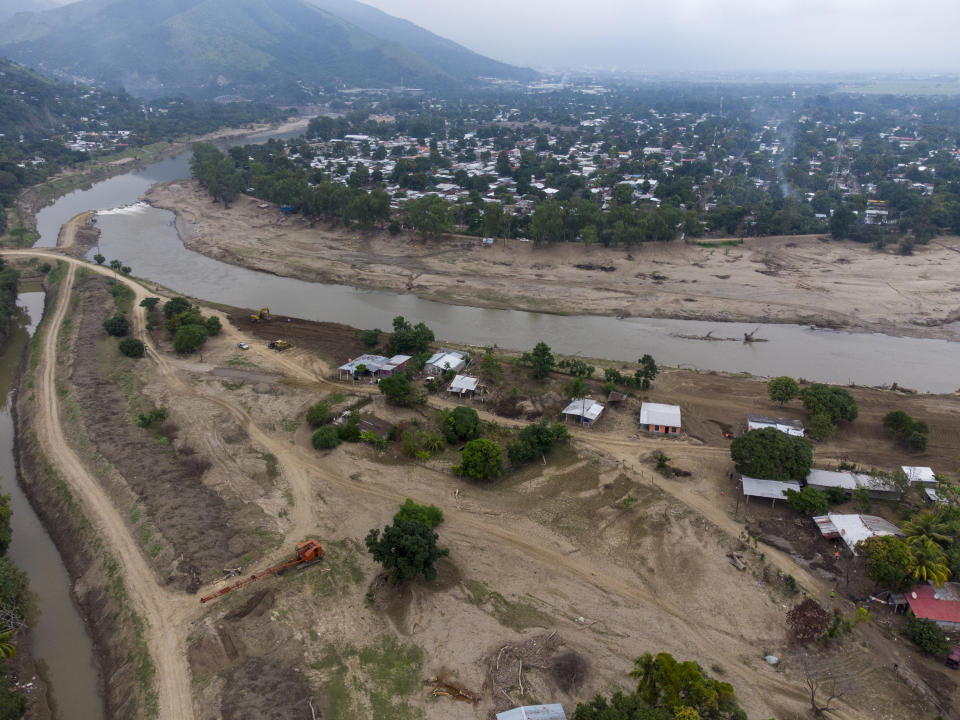 The Chamelecon River flows by the Saviñon Cruz neighborhood which was completely submerged during last year's hurricanes Eta and Iota in San Pedro Sula, Honduras, Tuesday, Jan. 12, 2021. The dual hurricanes affected an estimated 4 million Honduras’ 10 million people, and the northern territory has also been Honduras' hardest hit by COVID-19 infections. (AP Photo/Moises Castillo)