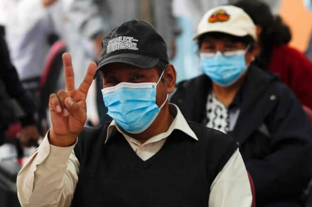 A man flashes a victory sign after getting a shot of the Sputnik V vaccine for COVID-19 in La Paz, Bolivia, in April. The Russian vaccine and Chinese vaccines are the only ones available in many parts of the world.