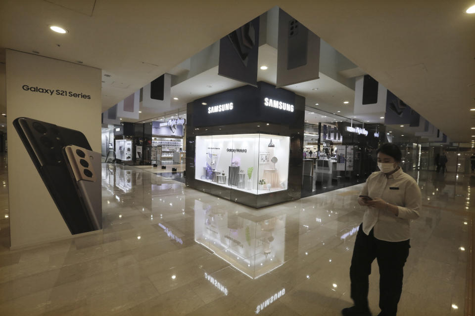 A woman passes by an advertisement of Samsung Electronics' Galaxy S21 Series smartphones at its shop in Seoul, South Korea, Thursday, Jan. 28, 2021. Samsung Electronics Co. said Thursday its operating profit for last quarter rose by more than 26% as it capped off a robust business year where its dual strength in parts and finished products allowed it to thrive amid the pandemic. (AP Photo/Ahn Young-joon)