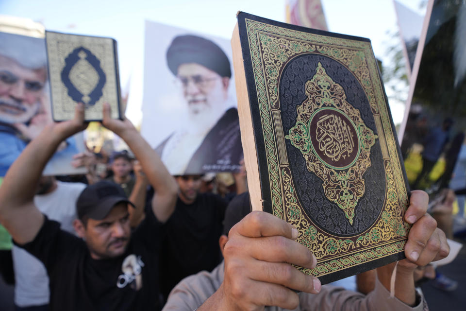 Iraqis raise copies of the Quran, Muslims' holy book, during a protest in Baghdad, Iraq, Saturday, July 22, 2023. Hundreds of protesters have attempted to storm Baghdad’s heavily fortified Green Zone, which houses foreign embassies and the seat of Iraq’s government, following reports of the burning of a Quran by a ultranationalist group in front of the Iraqi Embassy in Copenhagen. (AP Photo/Hadi Mizban)