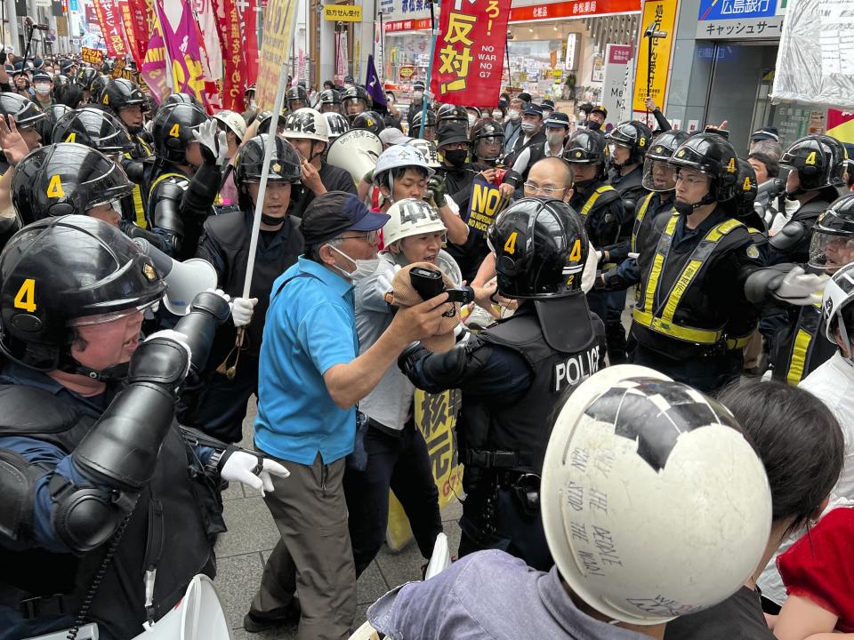 Protesters confront riot police during a march against the Group of Seven (G7) meeting being held in Hiroshima, western Japan, Sunday, May 21, 2023. (AP Photo/Adam Schreck)