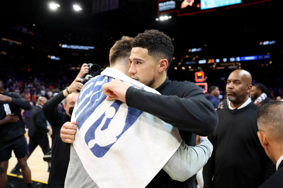 PHOENIX, ARIZONA - MAY 15: Luka Doncic #77 of the Dallas Mavericks hugs Devin Booker #1 of the Phoenix Suns after the Dallas Mavericks defeated the Phoenix Suns 123-90 in Game Seven of the 2022 NBA Playoffs Western Conference Semifinals at Footprint Center on May 15, 2022 in Phoenix, Arizona. NOTE TO USER: User expressly acknowledges and agrees that, by downloading and/or using this photograph, User is consenting to the terms and conditions of the Getty Images License Agreement. (Photo by Christian Petersen/Getty Images)