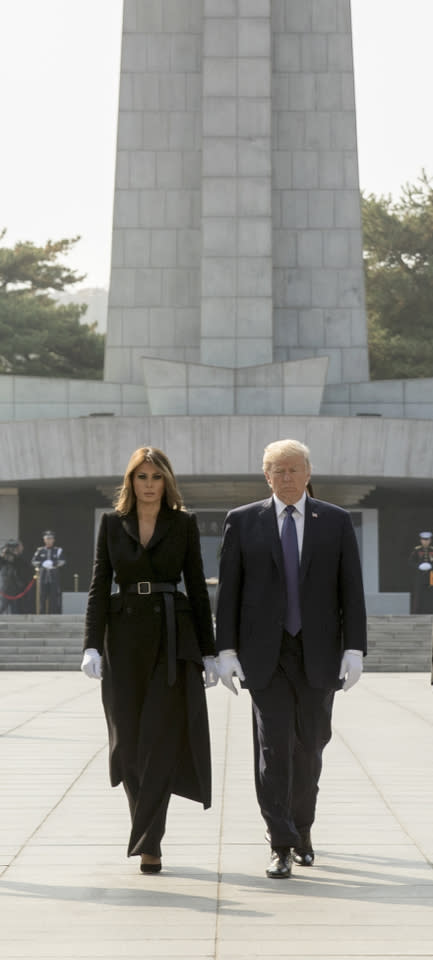 <p>Es müssen nicht immer Kleider und Röcke sein! Auf dem nationalen Friedhof in Südkorea überraschte die Mutter von Barron Trump in dunkler Marlene-Hose und Trenchcoat. (Bild-Copyright: Andrew Harnik/AP Photo) </p>