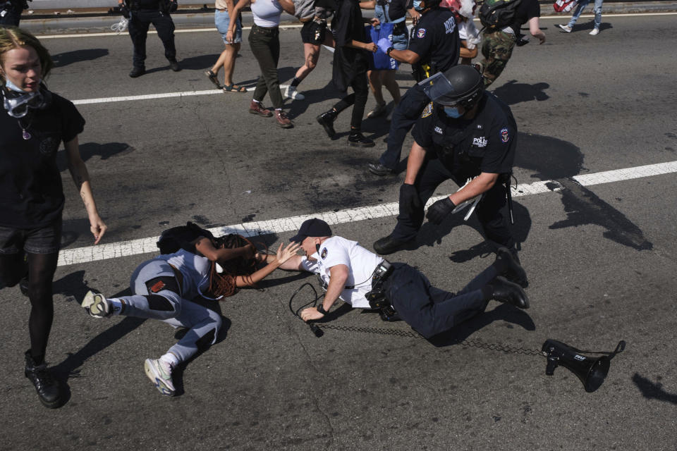 Black Lives Matter protesters are arrested by NYPD officers on the Brooklyn Bridge, Wednesday, July 15, 2020, in New York. Several New York City police officers were attacked and injured Wednesday on the Brooklyn Bridge during a protest sparked by the death of George Floyd, police said. At least four officers were hurt, including the department’s chief, and more than a dozen people were arrested. (AP Photo/Yuki Iwamura)