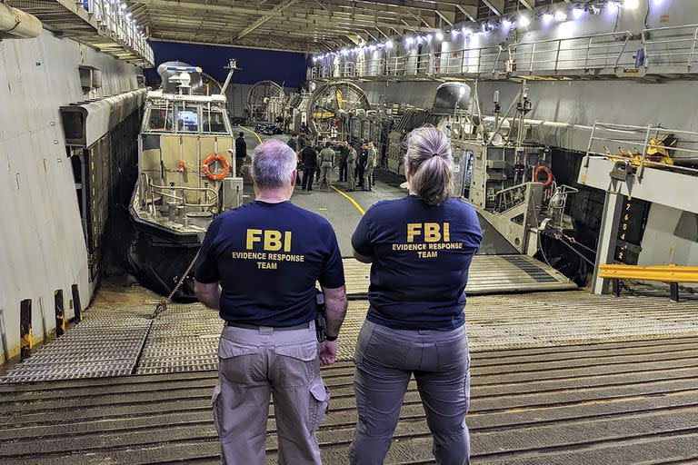 Los miembros del equipo de respuesta de evidencia del FBI observan las operaciones de recuperación del globo de gran altitud que fue derribado, en un barco del Departamento de Defensa frente a la costa de Myrtle Beach, S.C.