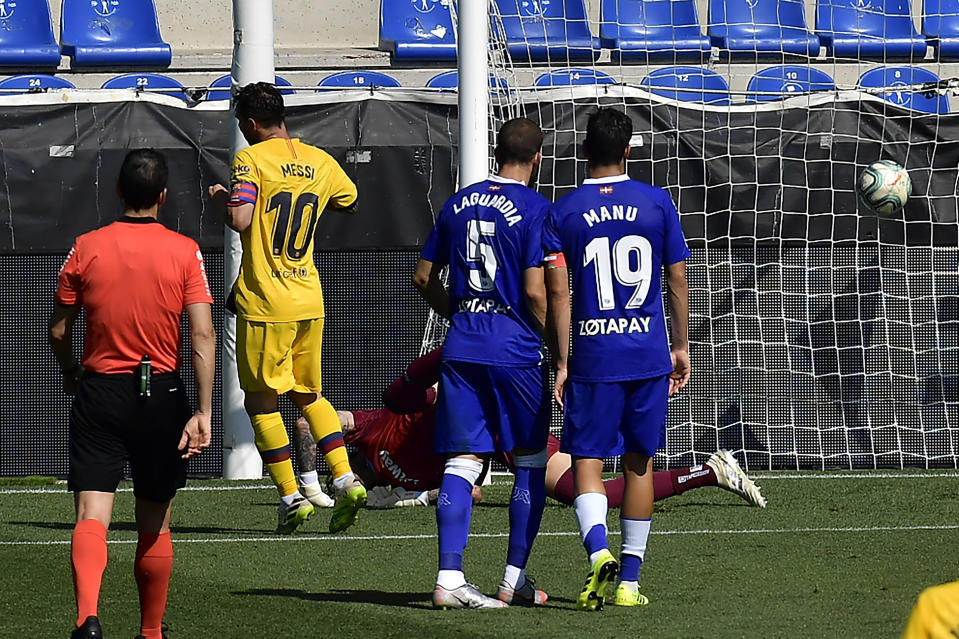 Barcelona's Lionel Messi, left, scores against Alaves during the Spanish La Liga soccer match between Alaves and FC Barcelona, at Mendizorroza stadium, in Vitoria, northern Spain, Sunday, July 19, 2020. (AP Photo/Alvaro Barrientos)