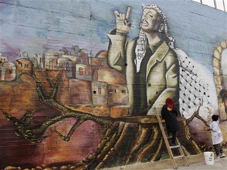 Palestinian university art students work on a mural depicting late Palestinian leader Yasser Arafat in the West Bank city of Nablus November 7, 2013. REUTERS/Abed Omar Qusini
