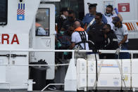 Italian Firefighters scuba divers bring ashore in a bag the body of one of the victims of the UK flag vessel Bayesian, Wednesday, Aug. 21, 2024. The sail yacht was hit by a violent sudden storm and sunk early Monday, while at anchor off the Sicilian village of Porticello near Palermo, in southern Italy. (AP Photo/Salvatore Cavalli)