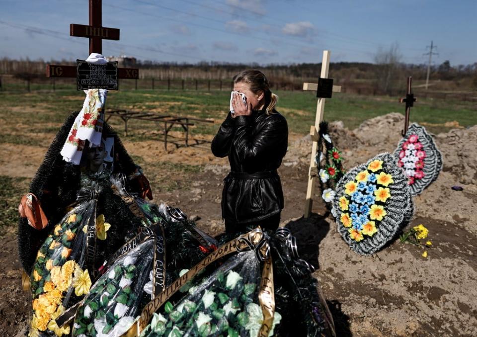 Irina Tromsa, 50,  who said her son Bohdan Tromsa, 25, a territorial defence member, was killed by Russian troops on the frontline near Sumy,   wipes her tears as she mourns by his grave after his burial at the cemetery in Bucha (REUTERS)