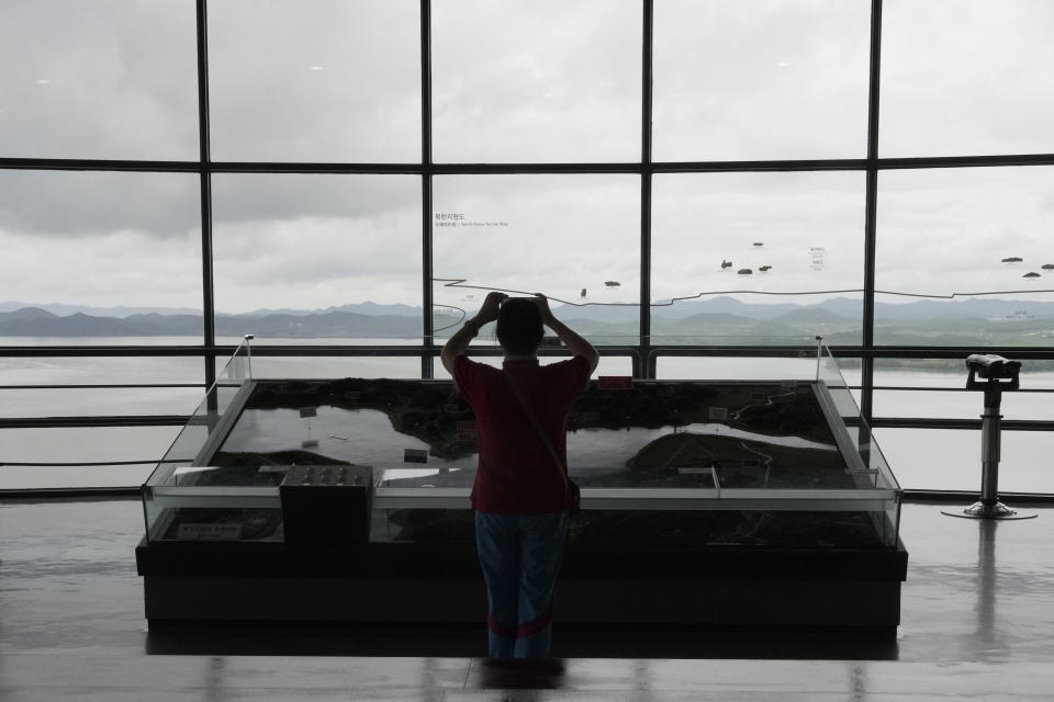 A visitor takes photos toward the North Korea side from the Unification Observation Post in Paju, South Korea, near the border with North Korea, Wednesday, July 24, 2024. (AP Photo/Ahn Young-joon)