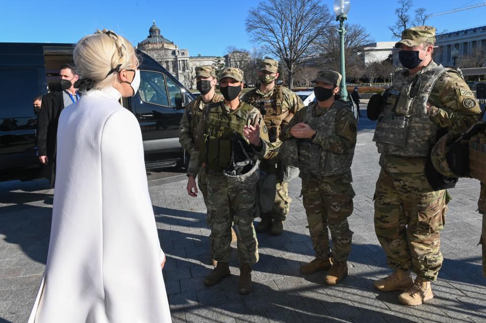 TOPSHOT - US singer, Lady Gaga (L), greets National Guard soldiers as she leaves the US Capitol building after rehearsing on January 19, 2021, for the inauguration of US President-elect Joe Biden in Washington, DC. (Photo by ROBERTO SCHMIDT / AFP) (Photo by ROBERTO SCHMIDT/AFP via Getty Images)