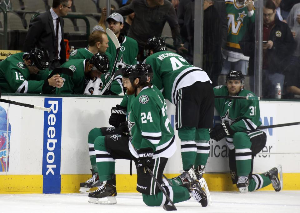 Dallas Stars right wing Alex Chiasson (12) bows his head on the bench as defenseman Jordie Benn (24) takes a knee on the ice after play was stopped in the first period of an NHL Hockey game against the Columbus Blue Jackets, Monday, March 10, 2014, in Dallas. Stars center Rich Peverly was taken to a hospital after a medical emergency. (AP Photo/Sharon Ellman)