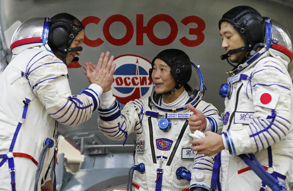 Roscosmos cosmonaut Alexander Misurkin, left, space flight participants Yusaku Maezawa, center, and Yozo Hirano attend a training session ahead of the expedition to the International Space Station at the Gagarin Cosmonauts' Training Center in Star City outside Moscow, Russia, Thursday, Oct. 14, 2021. A Japanese fashion tycoon who's booked a SpaceX ride to the moon is going to try out the International Space Station first. Yusaku Maezawa announced that he's bought two seats on a Russian Soyuz capsule. He'll blast off in December on the 12-day mission with his production assistant and a professional cosmonaut. (Shamil Zhumatov/Pool Photo via AP)