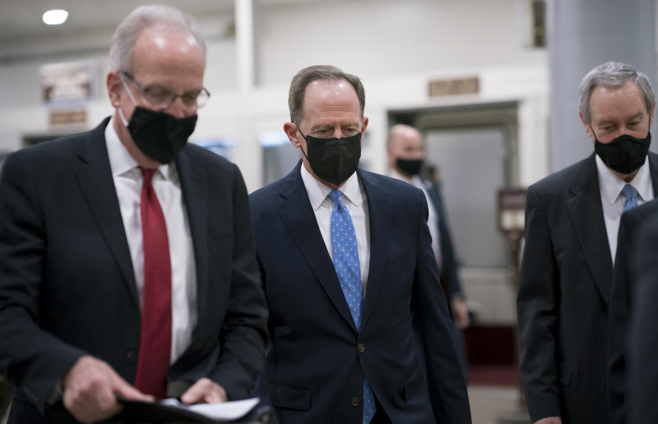 Sen. Jerry Moran, R-Kan., left, Sen. Pat Toomey, R-Pa., and others head to the chamber as the Senate holds a voting marathon on the Democrats' $1.9 trillion COVID-19 relief bill that's expected to end with the chamber's approval of the measure, at the Capitol in Washington, Friday, March 5, 2021. (AP Photo/J. Scott Applewhite)