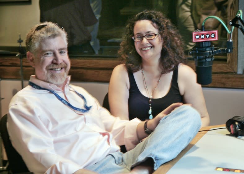 A man and a woman pose together in a radio studio