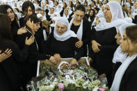 Members of the Israeli Druze minority mourn around the body of Tiran Fero, 17, during his funeral in Daliyat al-Carmel, Israel, Thursday, Nov. 24, 2022. Fero's body, which was taken by Palestinian militants on Wednesday from a West Bank hospital where he was seeking treatment after a car accident, was returned to his family on Thursday. (AP Photo/Mahmoud Illean)