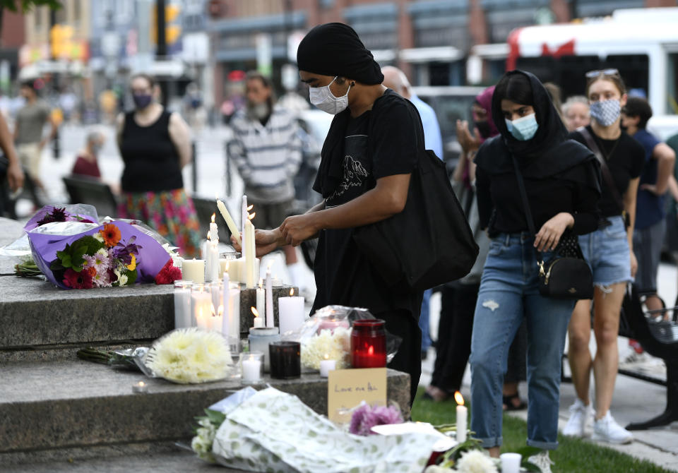 <p>A mourner lights a candle at a memorial for the four family members who were killed in a vehicle attack that police say was motivated by anti-Muslim hate, in London, Ont., in Ottawa, on Tuesday, June 8, 2021. THE CANADIAN PRESS/Justin Tang</p> 