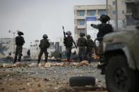 Israeli security forces hold a position during clashes with Palestinian stone throwers in Beit El on October 7, 2015