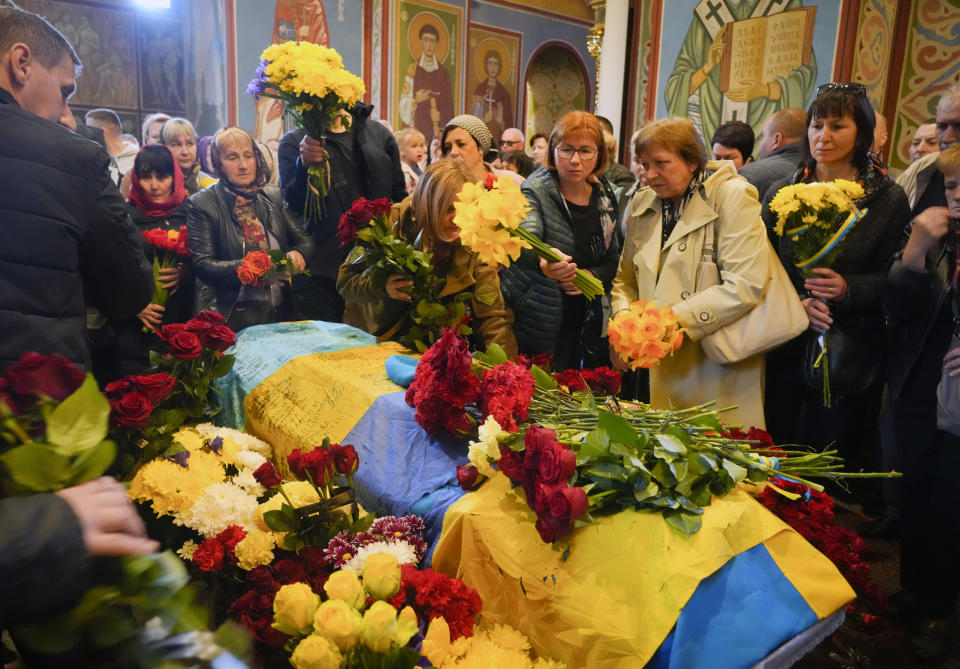 People pay their respects during the funeral ceremony for Ukrainian serviceman Ruslan Borovyk killed by the Russian troops in a battle in St Michael cathedral in Kyiv, Ukraine, Wednesday, May 4, 2022. (AP Photo/Efrem Lukatsky)