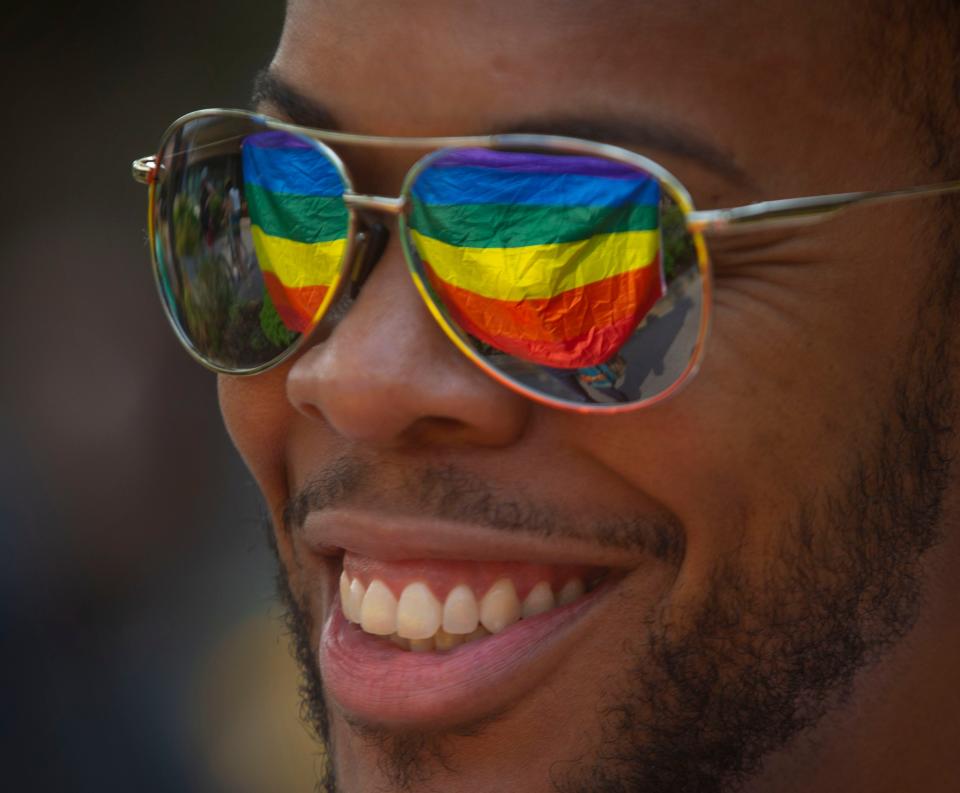 A rainbow Pride flag is reflected in the sunglasses of Kyle Rodriguez-Hudson, executive director of TransPonder, during the march to the 2021 Eugene Pride in the Park on Aug. 14, 2021.