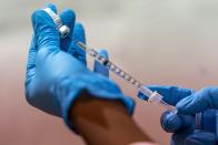 FILE — In this Jan. 31, 2021, file photo, pharmacist Diana Swiga fills a dead volume syringe with the Pfizer-BioNTech COVID-19 Vaccine, at a pop-up COVID-19 vaccination site at the Bronx River Houses Community Center, in the Bronx borough of New York. States including New York are wrestling with the decision of whether to allow medically vulnerable residents below the age of 65 to receive the coronavirus vaccine. (AP Photo/Mary Altaffer, File)