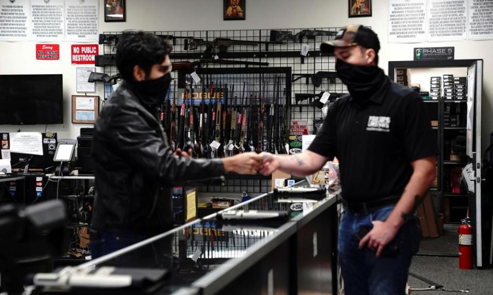 A customer hands over his ID for a background check to a manager before making a purchase at Firearms Unknown in Oceanside, California.