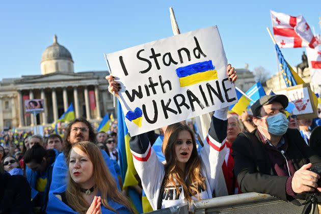 People hold placards and Ukrainian national flags in Trafalgar Square, during a 'London stands with Ukraine' protest march and vigil. (Photo: JUSTIN TALLIS via Getty Images)